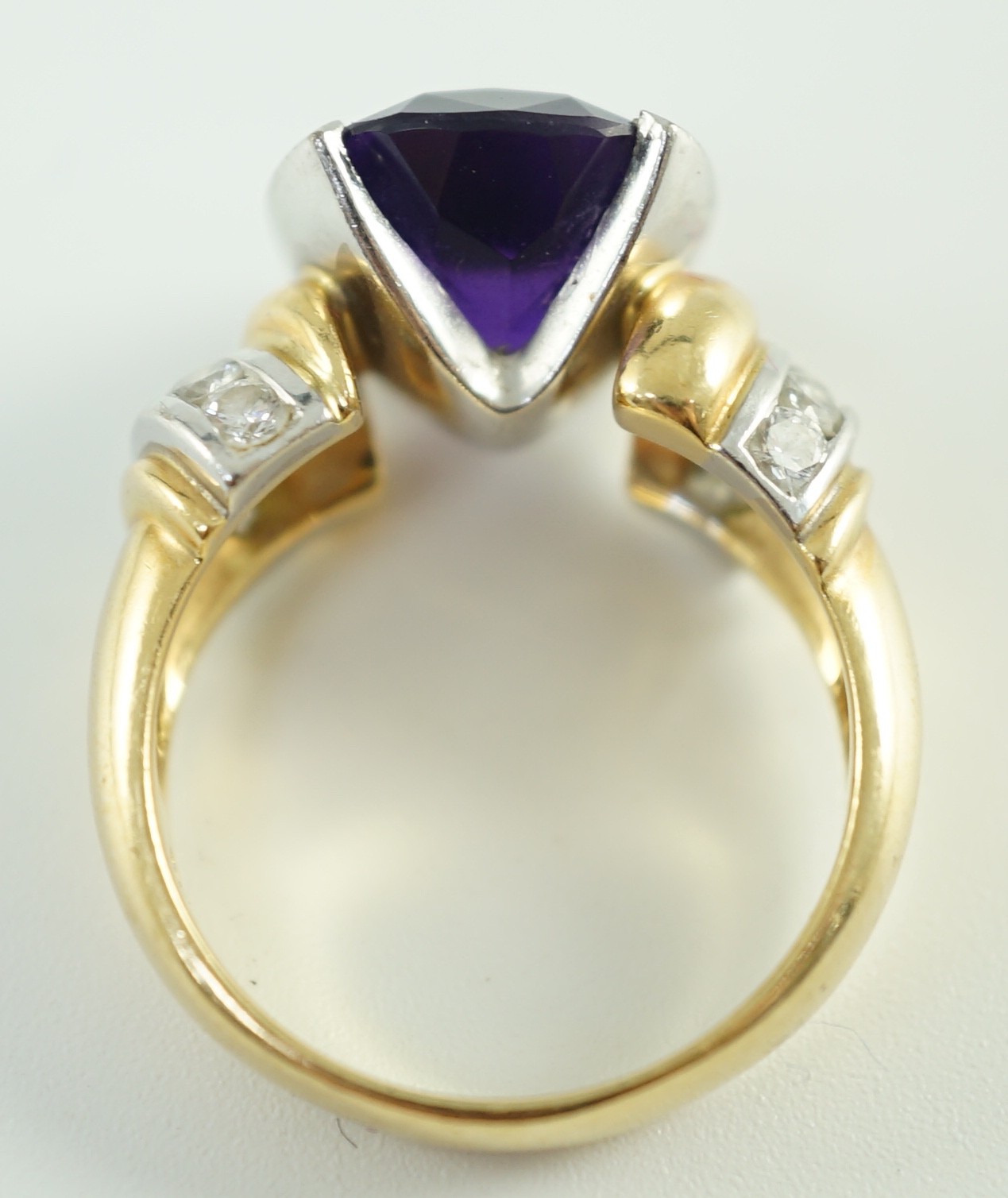 A modern 18ct gold and cushion cut amethyst set dress ring, with ten stone round cut diamond set shoulders